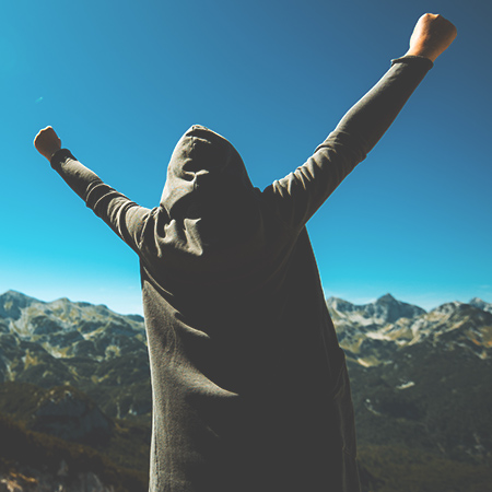 A victorious female person on a mountain top